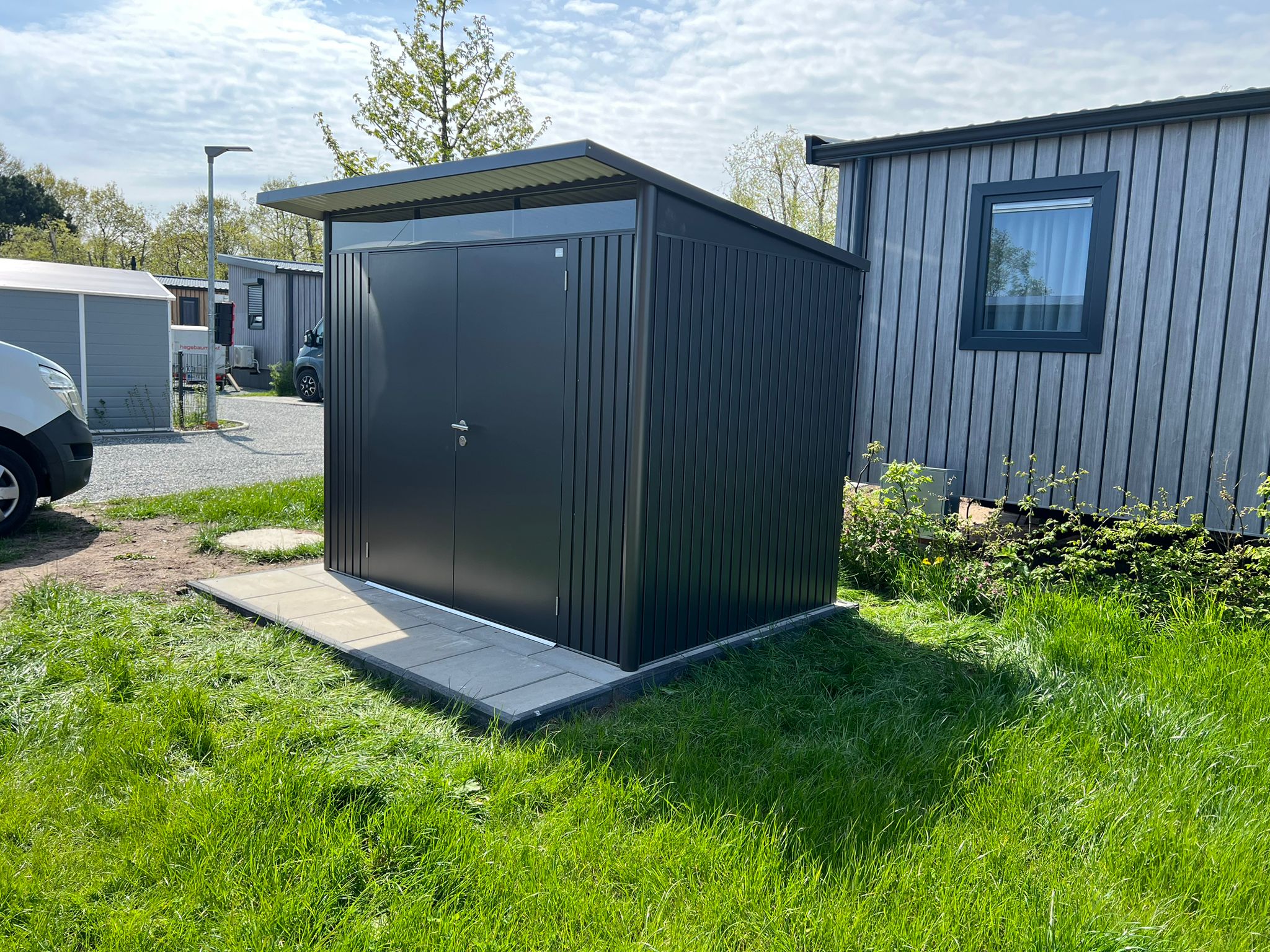 Montage eines modernen Metallgerätehauses auf gepflastertem Fundament – hochwertige Gartenhausinstallation durch HGB Holz- & Gartenbau.