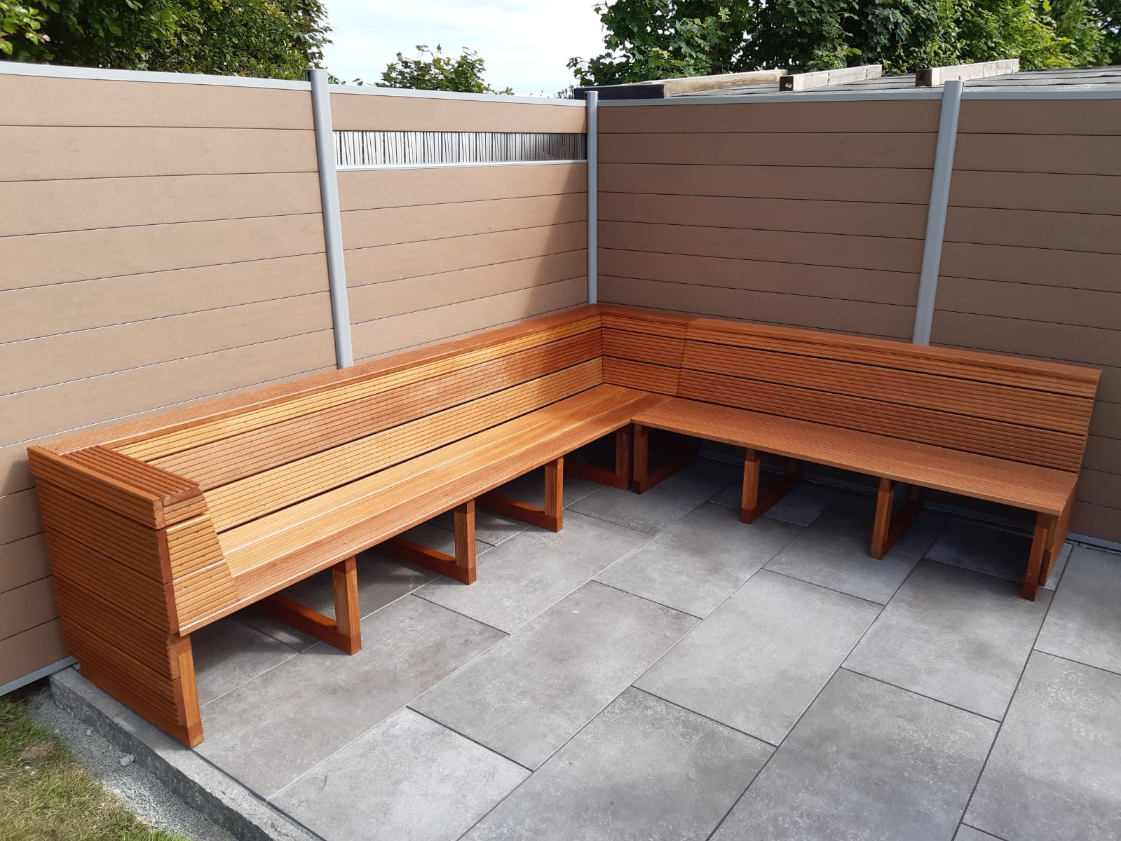 Eine maßgefertigte Eckbank aus glatten, horizontalen Holzlatten